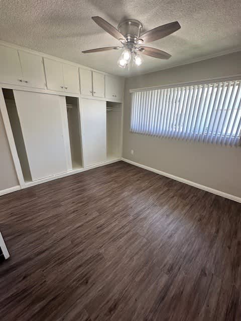 an empty living room with a ceiling fan