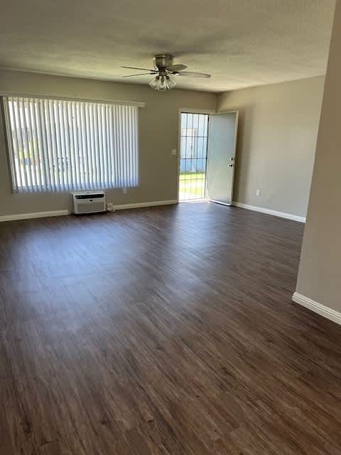 an empty living room with a ceiling fan