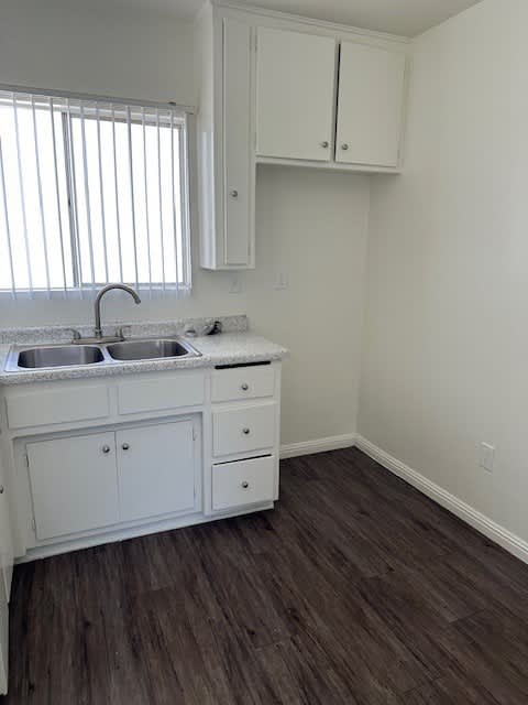 a kitchen with white cabinets and a sink