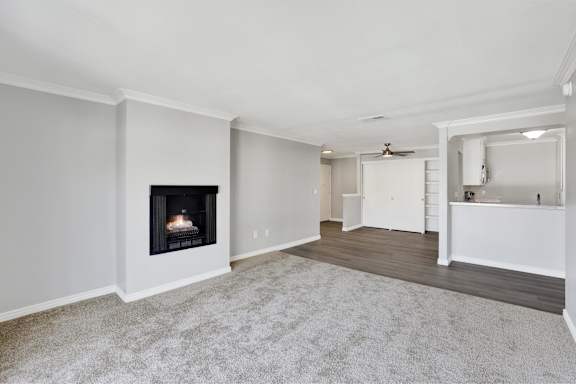 A living room with a fireplace and a kitchen area in the background. at THE STREAMS Apartments, California