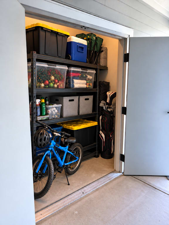 A blue bicycle is parked in a garage.
