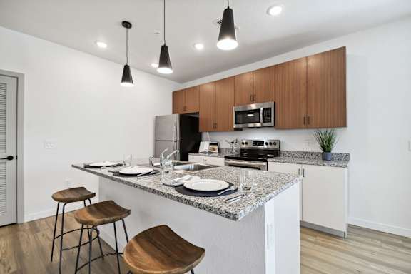 a kitchen with a granite counter top and a bar with stools