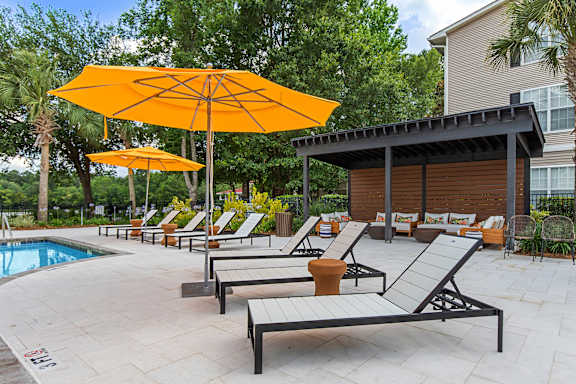 A poolside area with sun loungers and umbrellas.