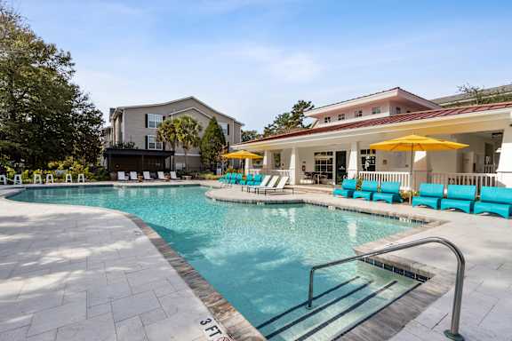 A swimming pool with a slide and sun loungers.