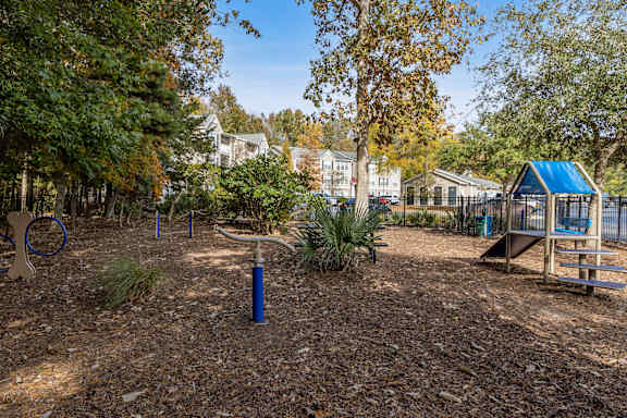A playground with a blue slide and a seesaw.