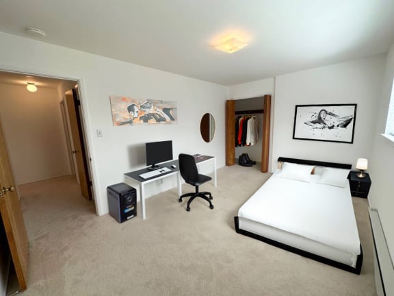 a bedroom with a bed and a desk in a room