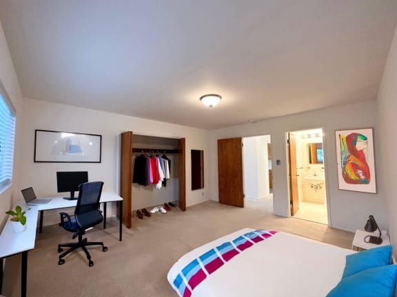 a bedroom with a bed and a desk in a room