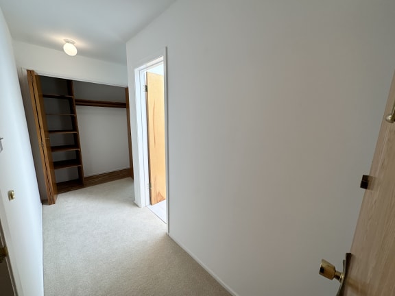 a bedroom with a closet and a door that is open