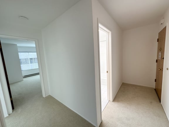 a bedroom with white walls and carpet