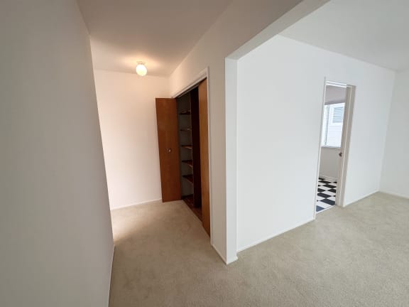 a view from the top of the stairs of a bedroom in a house with white walls and