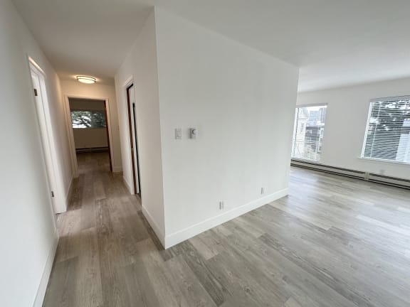 a bedroom with hardwood floors and white walls