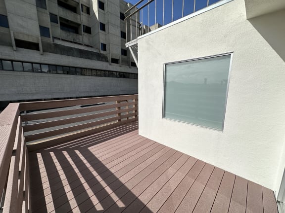 a large window in a white wall with a wooden deck
