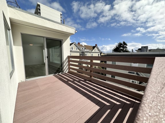a balcony with a wooden deck and a sliding glass door