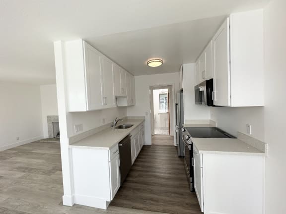 a kitchen with white cabinets and a wooden floor