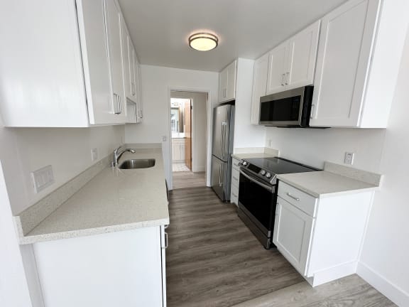 a kitchen with white cabinets and a black stove top oven