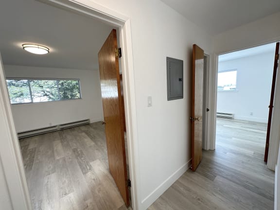 a bedroom with hardwood floors and white walls