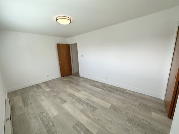 an empty room with hardwood floors and white walls