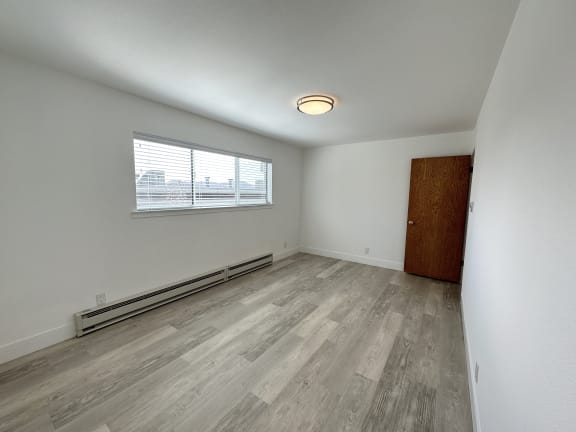 a bedroom with hardwood floors and white walls