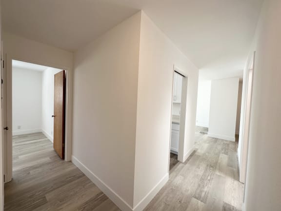 a bedroom with hardwood floors and white walls