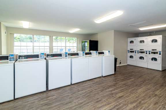 A laundry room with washers and dryers at Arbor Pointe at Hillcrest in Little Rock, AR