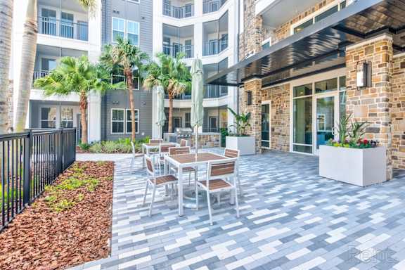 A patio with a table and chairs at Tapestry Nona in Orlando, FL