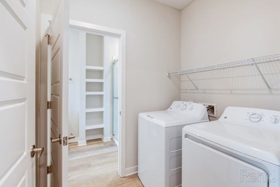 A white laundry room with a washer and dryer.