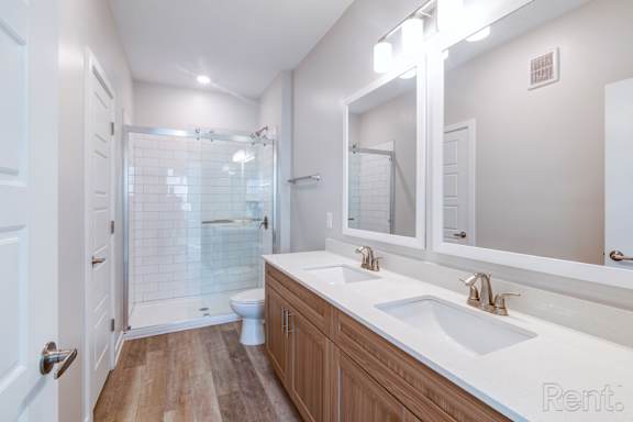 A bathroom with a white sink and a white toilet.