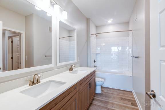 A white bathroom with a white tub and sink.