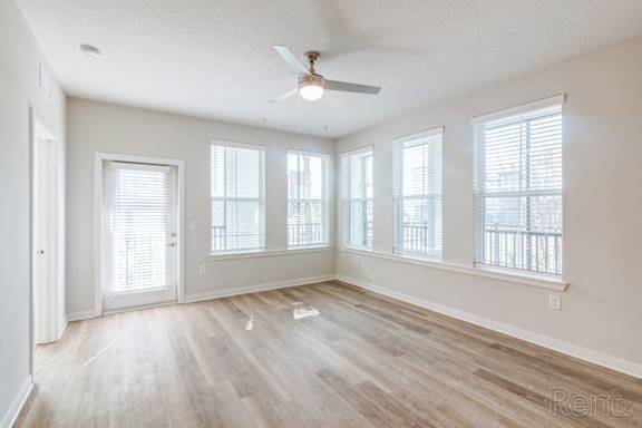 Oversized living room with natural light, wood floors, and ceiling fan at Tapestry Nona Apartments in Orlando, FL