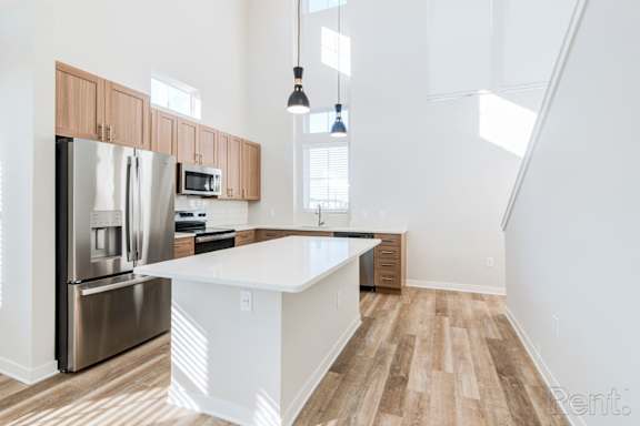 A kitchen with a white island and stainless steel appliances.