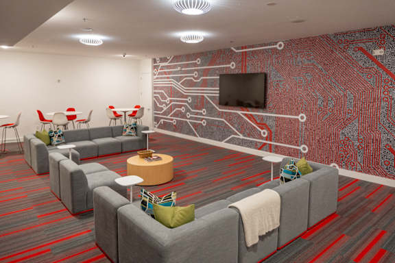 a room with couches and chairs and a wall with a television at 20 Midtown, Birmingham, 35233