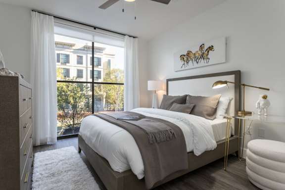 modern bedroom with natural light, ceiling fan, and wood plank flooring at 2020 Providence in Huntsville, AL