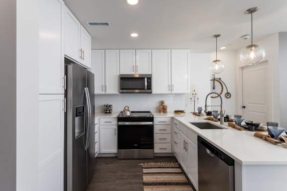 A modern kitchen with white cabinets and stainless-appliances at 2020 Providence in Huntsville, AL