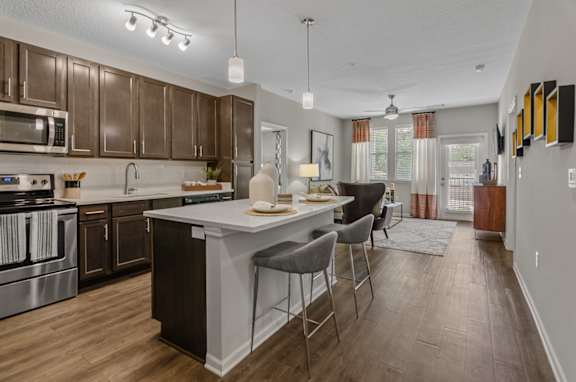 A modern kitchen with dark wood cabinets and a white island.
