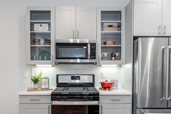 a kitchen with stainless steel appliances and white cabinets at Anthem Luxury Rentals and Apartments in Huntsville, AL