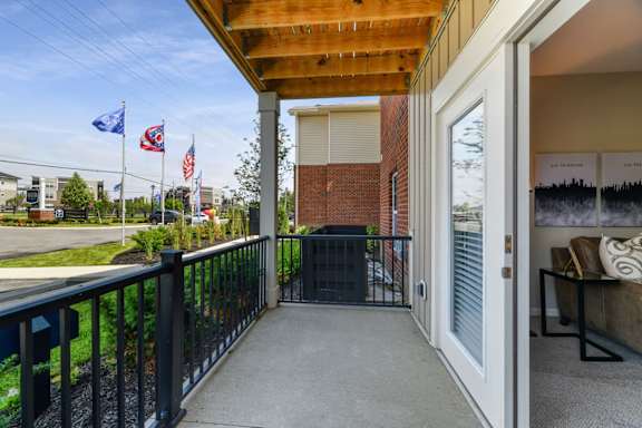 A balcony with a black railing and a wooden ceiling.