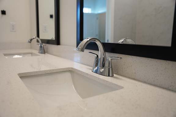 A bathroom sink with a chrome faucet and quartz countertops at West Row Lofts and Townhomes in Birmingham, AL
