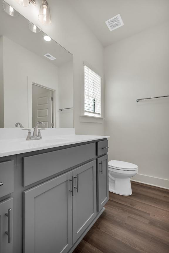A bathroom with a white toilet and a sink with a mirror at Turnberry Park Luxury Rental Homes
