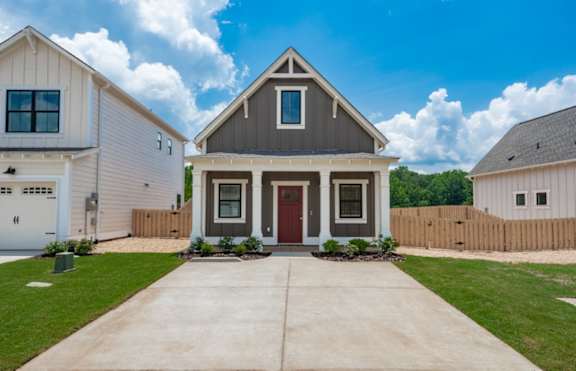 A modern house with a red door and a grey roof at Turnberry Park Luxury Rental Homes.