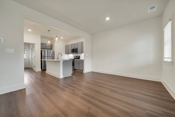 A kitchen with a white countertop and wooden floors at Turnberry Park Luxury Rental Homes.