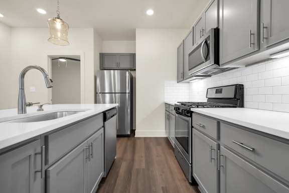 A modern kitchen with a stainless steel refrigerator and a white countertop at Turnberry Park Luxury Rental Homes.