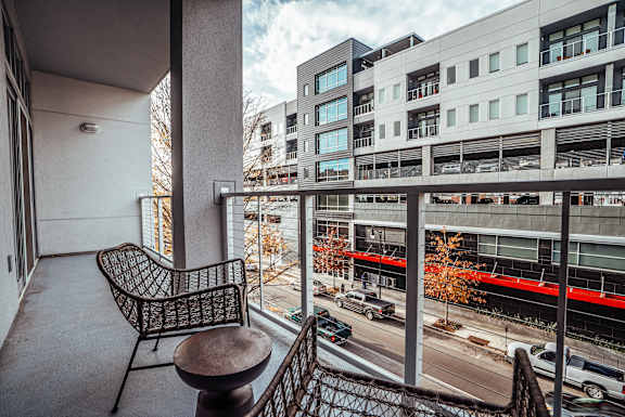 a balcony with a chair and a table overlooking a city street at 20 Midtown, Birmingham, AL, 35233