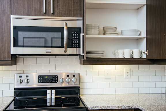 a kitchen with a stove and a microwave at 20 Midtown, Birmingham, Alabama