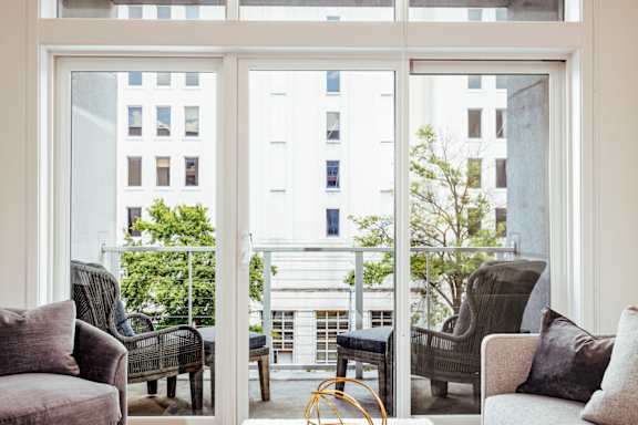 a living room with a couch and chairs and a balcony at 20 Midtown, Birmingham, AL, 35233
