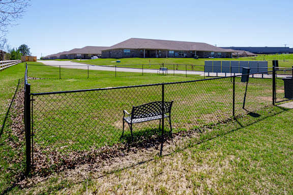 leash-free pet park with sitting area at The Oakley at Deerfield Apartments in Florence, AL
