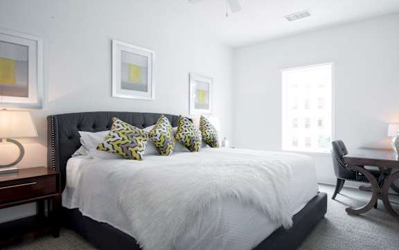 a bedroom with a large bed and a desk with a chair at 20 Midtown, Birmingham, Alabama
