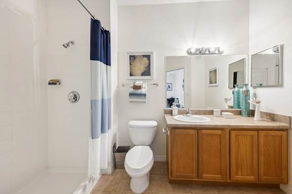 A bathroom with a toilet, sink, and shower.