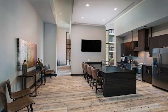 A modern kitchen with a bar area and a television mounted on the wall.