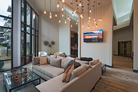 A modern living room with a glass coffee table and a large couch.