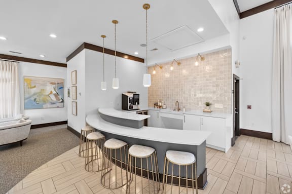 A modern kitchen with a bar area and stools.